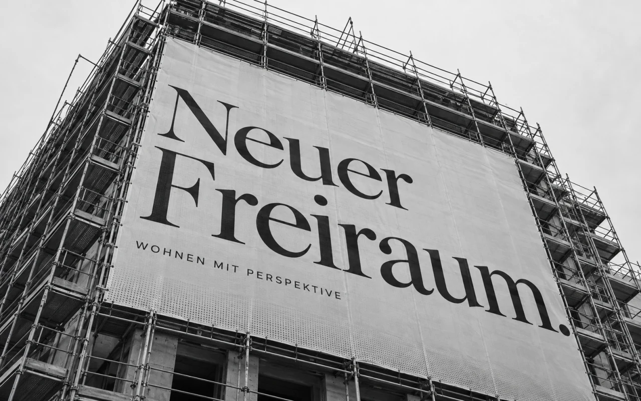 Schwarz-weißes Immobilien-Banner als großformatiger Druck auf einem Baugerüst
